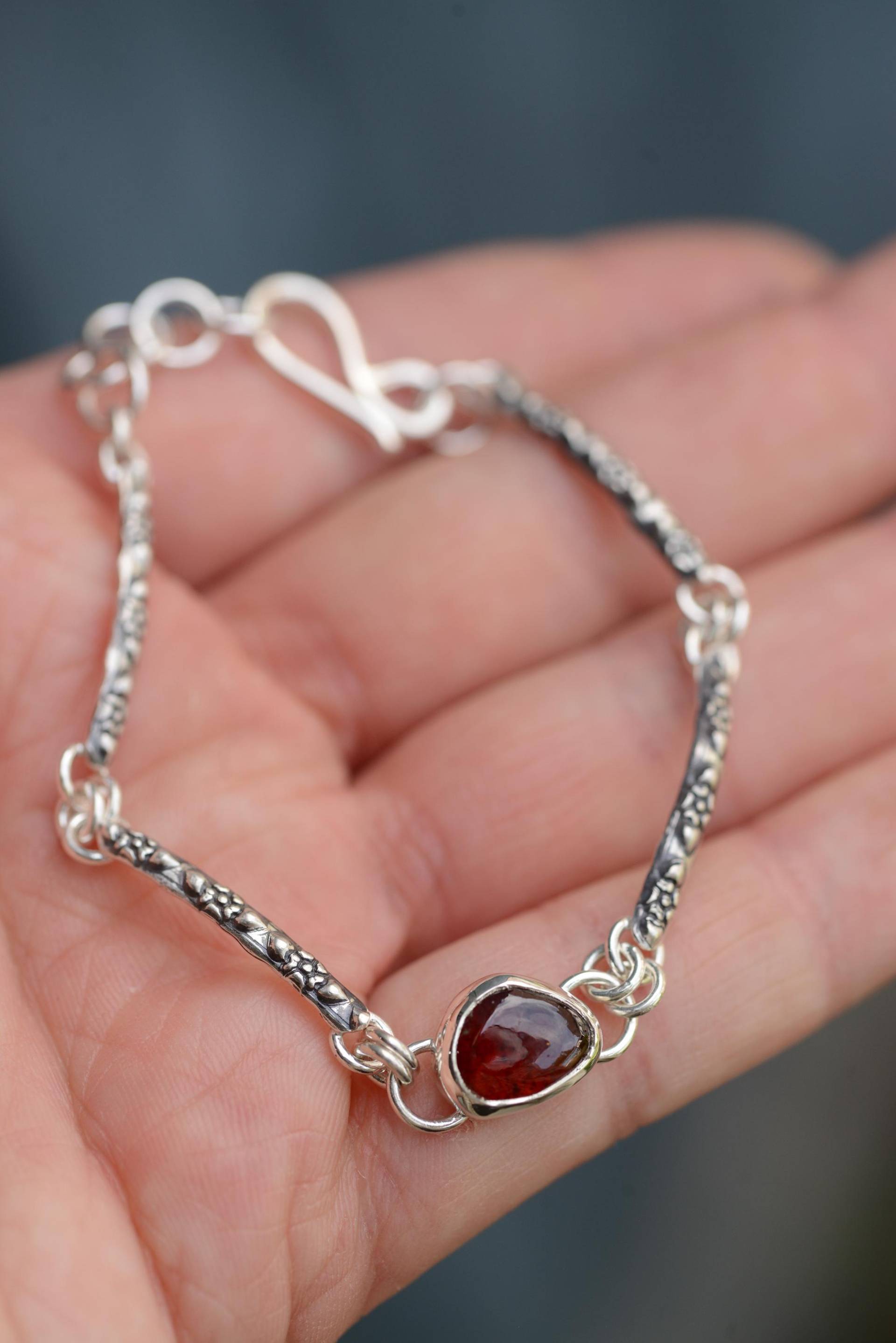 Silversmith Bracelet With Flower Texture & A Natural Red Garnet Gemstone, Handmade Oxidized Silver By Formvollendung Silversmith Bracelet With Flower Texture & A Natural Red Garnet Gemstone, Handmade Oxidized Silver By Formvollendung von Formvollendung