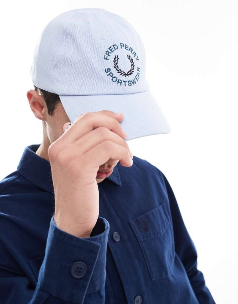 Fred Perry - Sportliche Kappe in Hellblau mit Grafik von Fred Perry