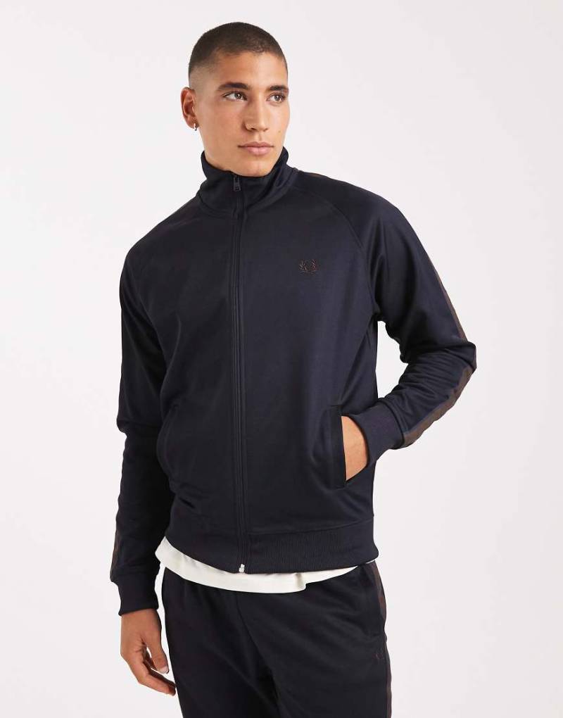Fred Perry - Trainingsjacke in Marineblau mit Kontrast-Zierband in Burnt Tobacco Fred Perry - Trainingsjacke in Marineblau mit Kontrast-Zierband in Burnt Tobacco von Fred Perry
