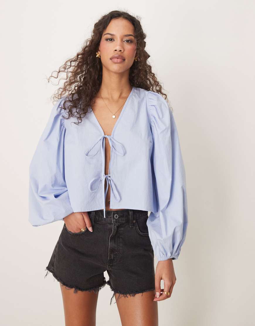 Gina Tricot - Blusenoberteil in Blau mit voluminösen Ärmeln und Bindedetails vorne Gina Tricot - Blusenoberteil in Blau mit voluminösen Ärmeln und Bindedetails vorne von GINA TRICOT