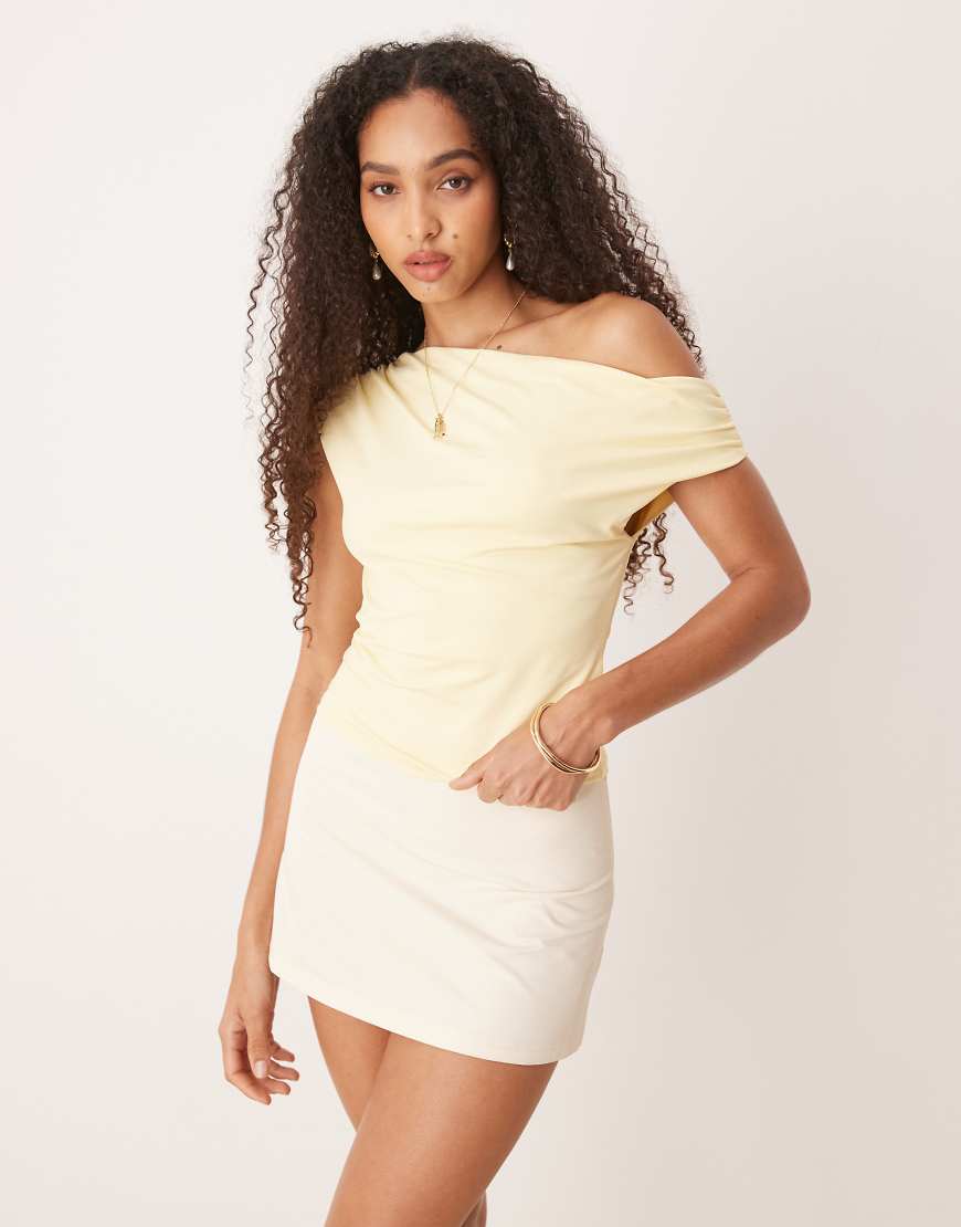 Gina Tricot - Gerafftes Oberteil aus anschmiegsamem Jersey in Buttergelb mit verdrehtem One-Shoulder-Träger Gina Tricot - Gerafftes Oberteil aus anschmiegsamem Jersey in Buttergelb mit verdrehtem One-Shoulder-Träger von GINA TRICOT