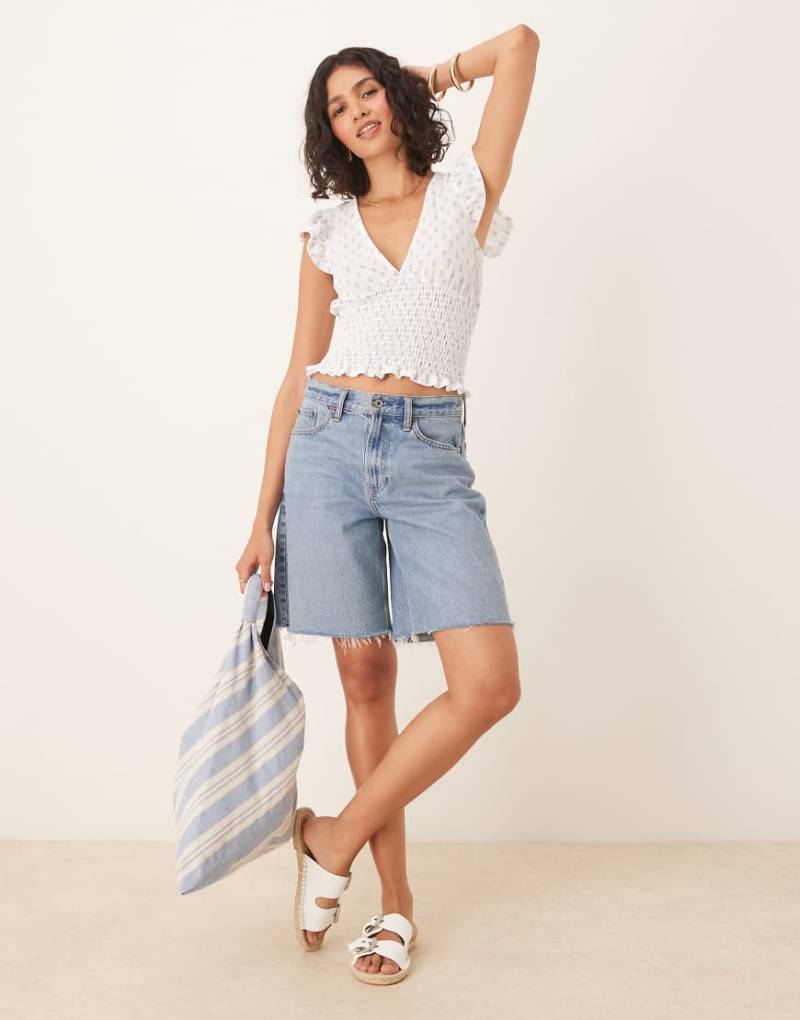 Gina Tricot - Kurzärmliges Oberteil in Weiß mit Rüschen, V-Ausschnitt und blauem Muster von GINA TRICOT