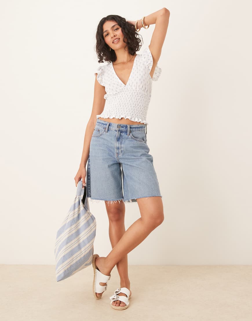 Gina Tricot - Kurzärmliges Oberteil in Weiß mit Rüschen, V-Ausschnitt und blauem Muster von GINA TRICOT