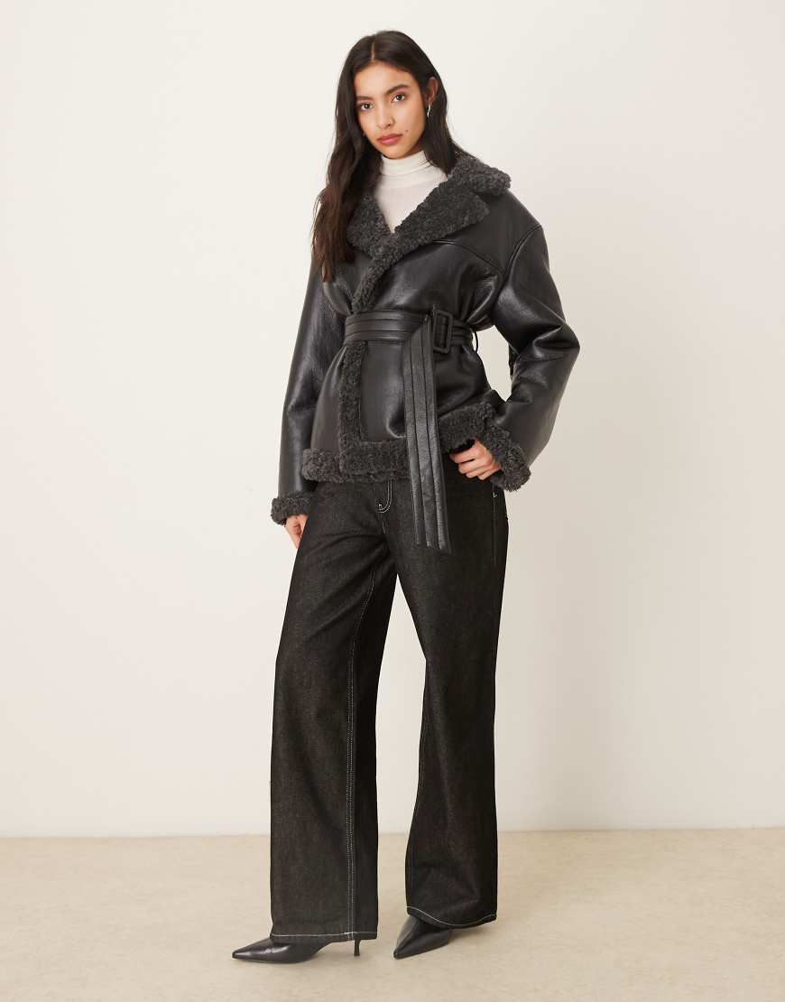 Gina Tricot - Kurze Jacke aus Teddy-PU in Schwarz mit Gürtel und dunkelgrauen Kragenbesätzen von GINA TRICOT