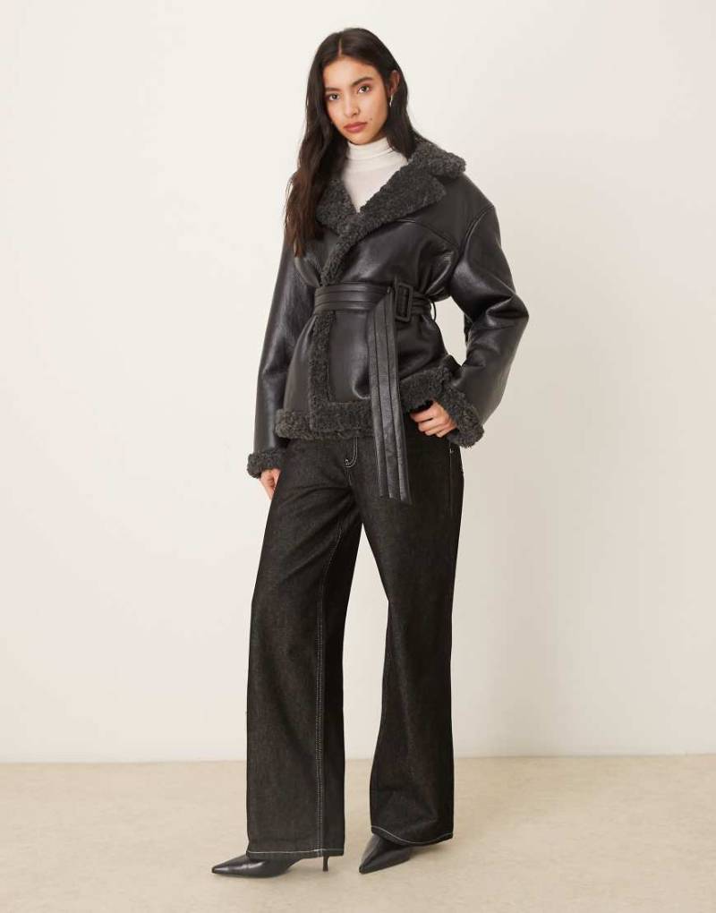 Gina Tricot - Kurze Jacke aus Teddy-PU in Schwarz mit Gürtel und dunkelgrauen Kragenbesätzen von GINA TRICOT