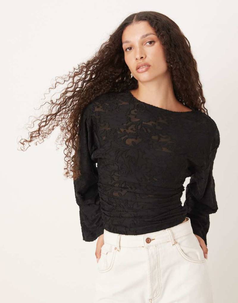 Gina Tricot - Langärmliges Oberteil in Schwarz mit strukturiertem Druck und Rundhalsausschnitt Gina Tricot - Langärmliges Oberteil in Schwarz mit strukturiertem Druck und Rundhalsausschnitt von GINA TRICOT