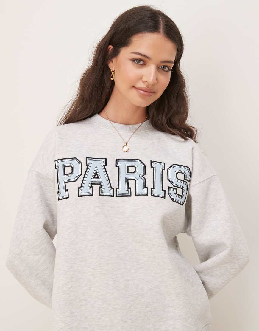 Gina Tricot - Paris - Oversize-Sweatshirt in Hellgrau meliert mit Logo Gina Tricot - Paris - Oversize-Sweatshirt in Hellgrau meliert mit Logo von GINA TRICOT