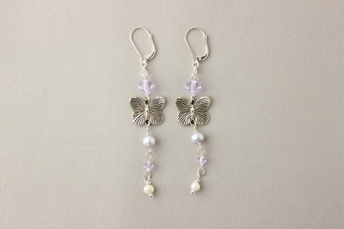 Schmetterlings-Ohrringe in Violett/Lila Mit Silberfarbenen Schmetterlingen, Swarovski-Kristallen Und Süsswasserperlen Schmetterlings-Ohrringe in Violett/Lila Mit Silberfarbenen Schmetterlingen, Swarovski-Kristallen Und Süsswasserperlen von GMHdesign