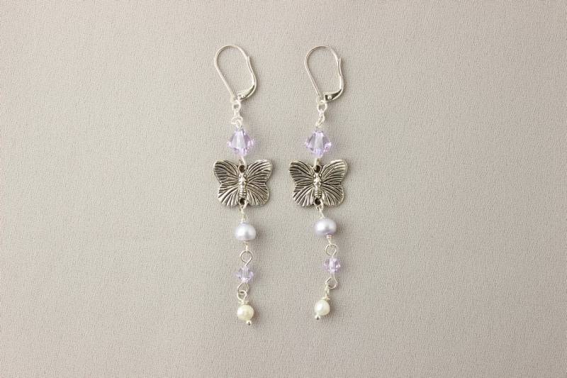 Schmetterlings-Ohrringe in Violett/Lila Mit Silberfarbenen Schmetterlingen, Swarovski-Kristallen Und Süsswasserperlen Schmetterlings-Ohrringe in Violett/Lila Mit Silberfarbenen Schmetterlingen, Swarovski-Kristallen Und Süsswasserperlen von GMHdesign
