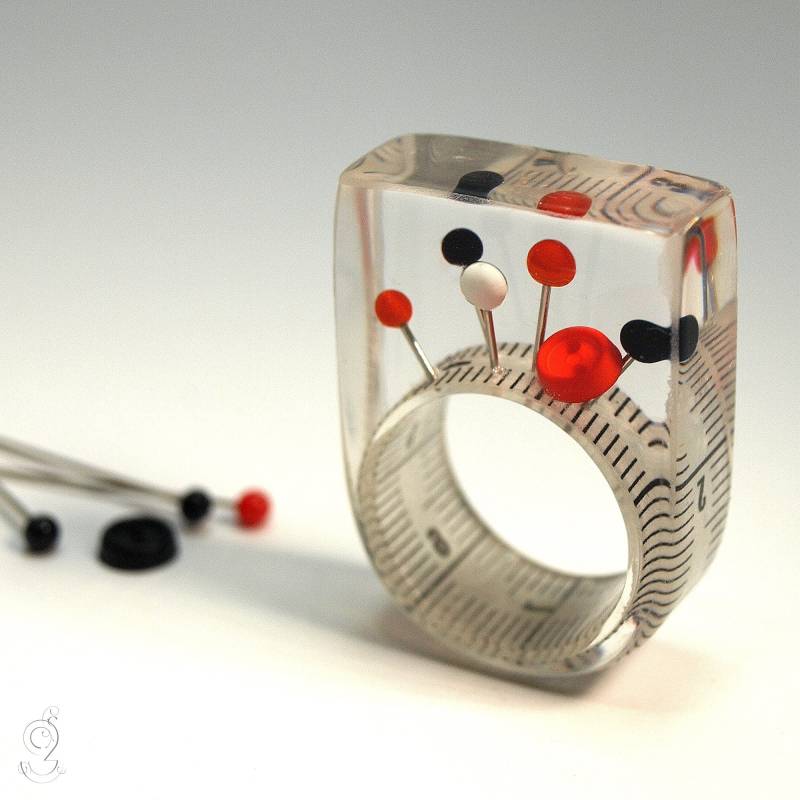 Nähkästchen Ring - Ungewöhnlicher Nähutensilien-Ring Mit Maßband, Bunten Stecknadeln Und Druckknopf Auf Weißem in Epoxidharz von GeschmeideUnterTeck
