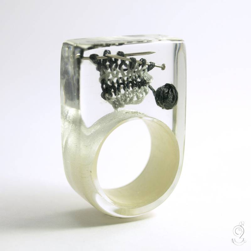 Ring Strickzeug - Außergewöhnlicher Strick-Ring Mit Grau Gestrickter Wolle Und Stricknadeln Auf Einem Blattweißgold in Epoxidharz von GeschmeideUnterTeck