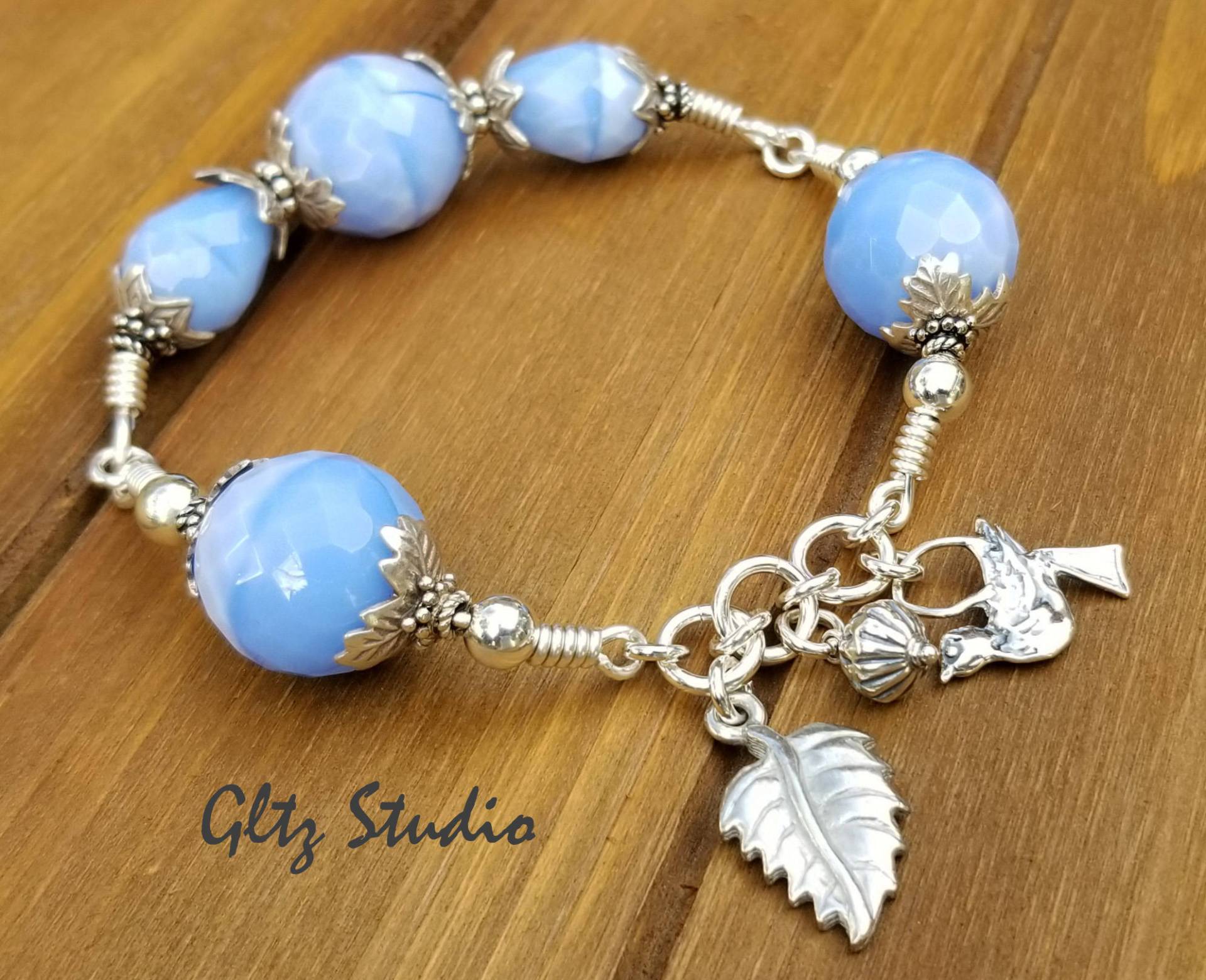 Hand Gewickelt Armreif Aus Sterlingsilber Hellblaues Glas, Vogel - Und Blattanhänger Hand Gewickelt Armreif Aus Sterlingsilber Hellblaues Glas, Vogel - Und Blattanhänger von GltzStudio