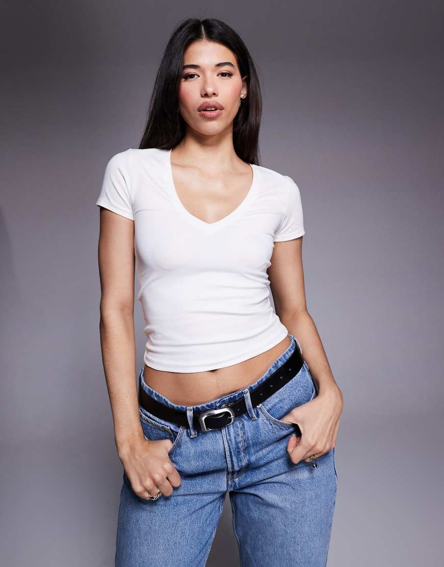 Good American - Knapp geschnittenes T-Shirt aus reiner Baumwolle in Weiß mit V-Ausschnitt von Good American