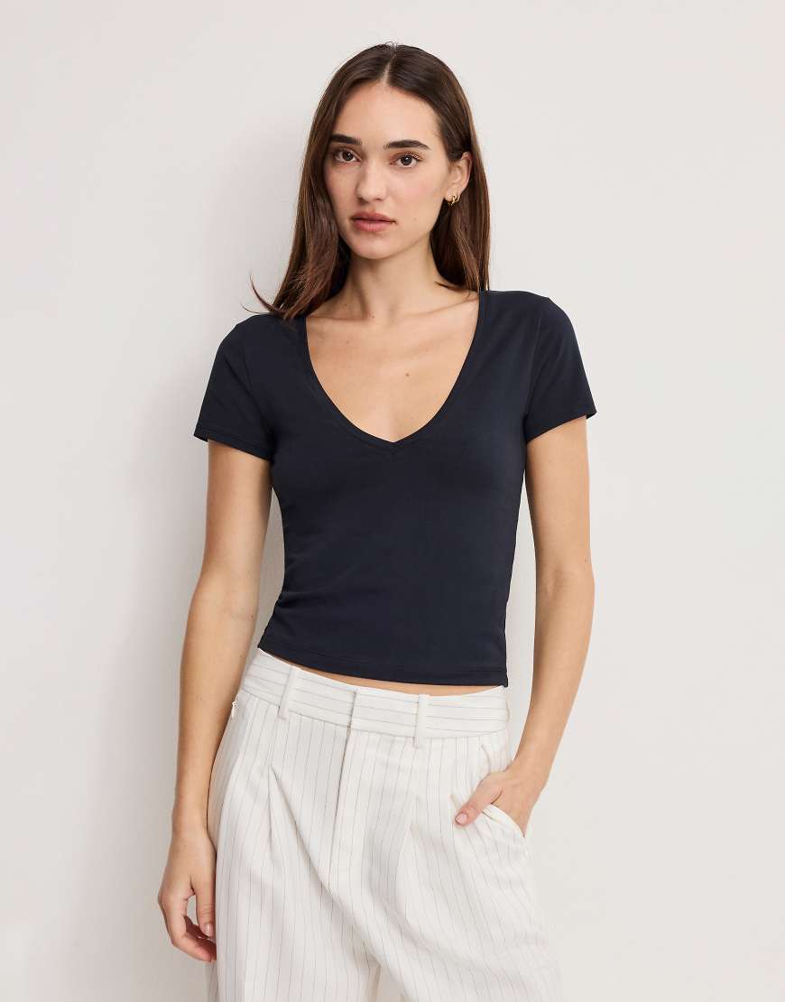 Good American - Knapp geschnittenes T-Shirt in Schwarz mit V-Ausschnitt von Good American