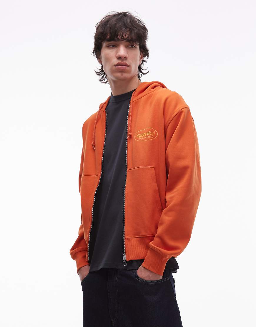 Gramicci - Kapuzenjacke in Burnt Orange mit „Original Freedom"-Grafikprint von Gramicci