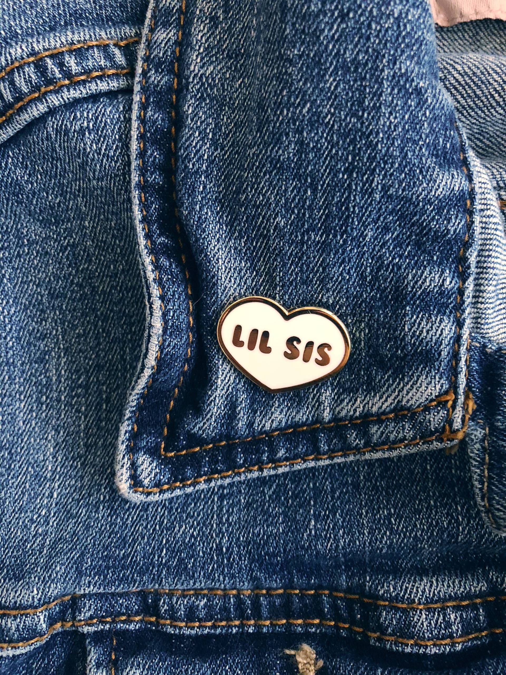 Ein Weißer, Herzförmiger Emaille-Pin Von Lil Sis Ein Weißer, Herzförmiger Emaille-Pin Von Lil Sis von GreekLifeFlair