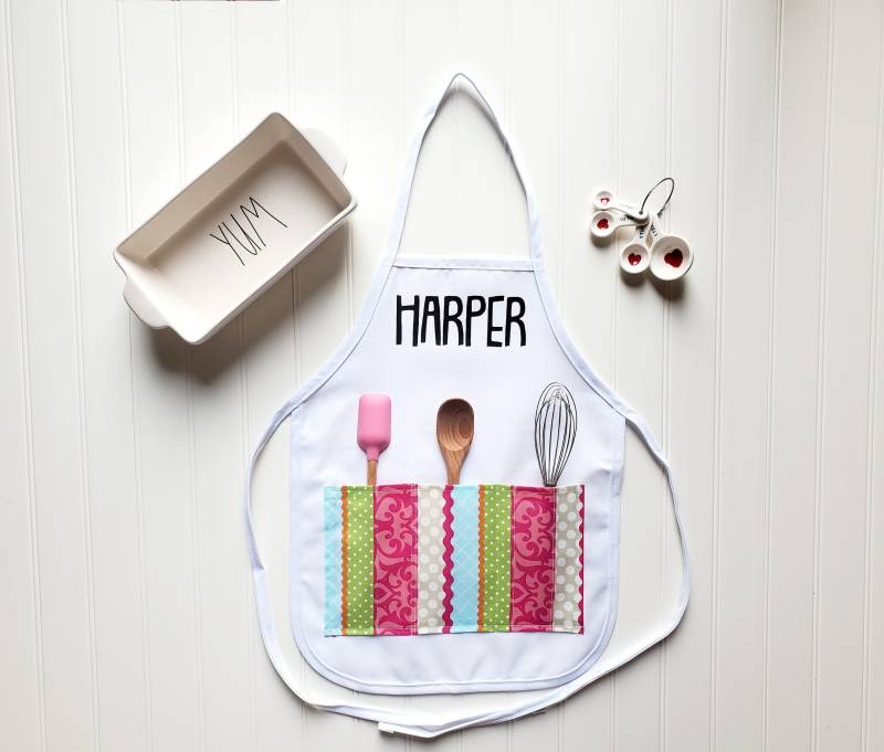 Personalisierte Weiße Kinderschürze Mit 3 Bunt Gestreiften Taschen Personalisierte Weiße Kinderschürze Mit 3 Bunt Gestreiften Taschen von GrowingRootsShop