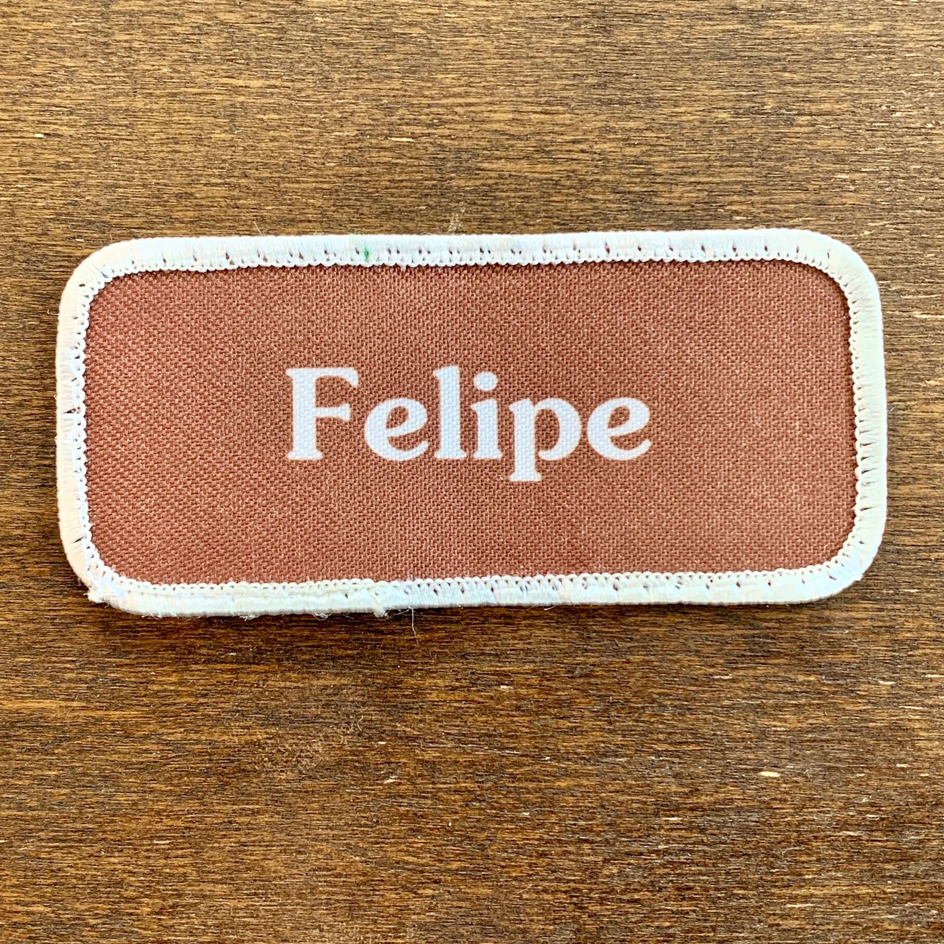 Felipe. Ein Brauner Arbeitsshirt Aufnäher Mit Der Aufschrift "Felipe" in Weißer Schrift Umrandung von HeydayRetroMart