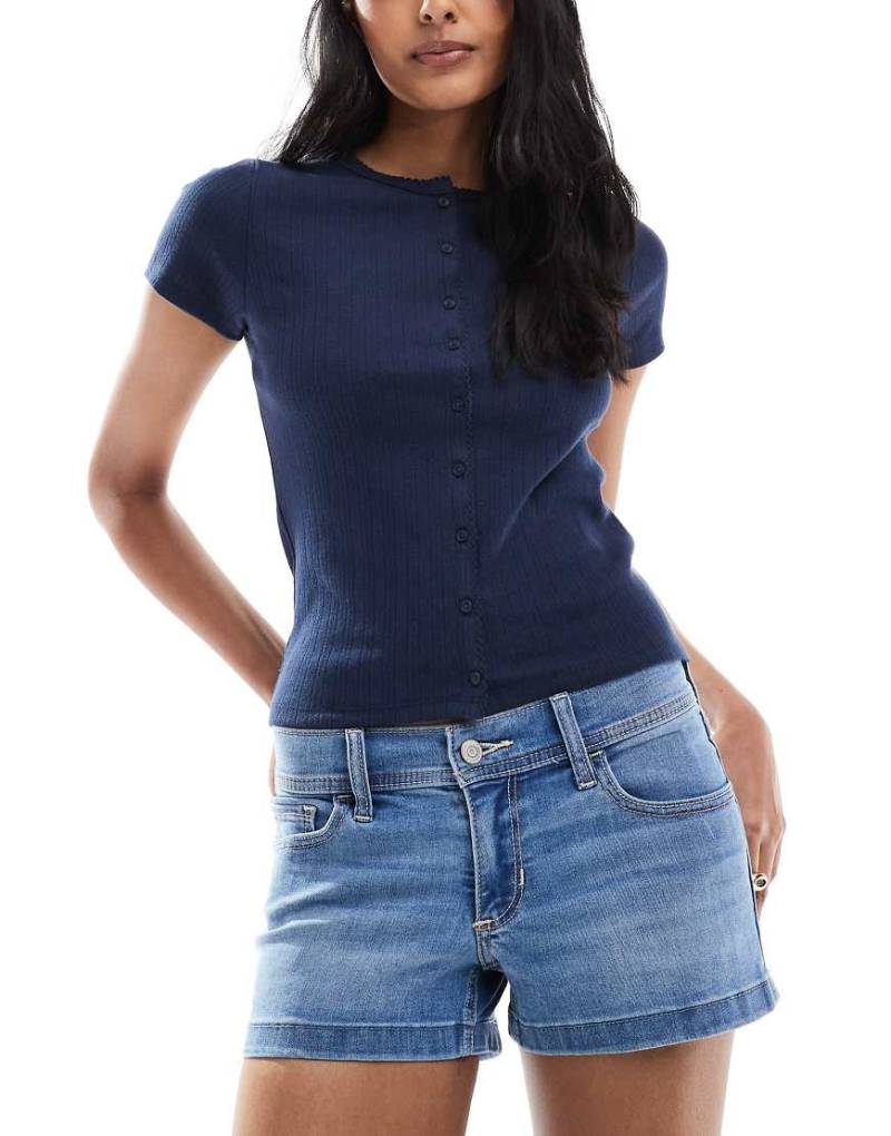 Hollister - Mini-Jeansshorts in mittelblauer Waschung mit tiefem Bund und geschlitztem Saum Hollister - Mini-Jeansshorts in mittelblauer Waschung mit tiefem Bund und geschlitztem Saum von Hollister