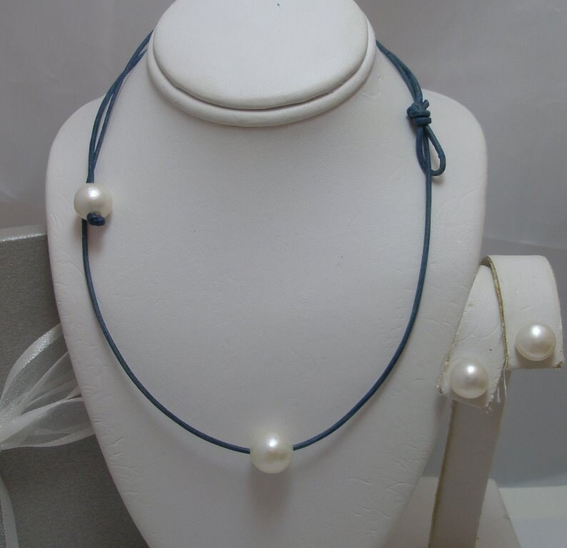 Floating Solitaire Echte Natürliche Weiße Runde Perlenkette Mit Perle Knebelverschluss Und Ohrringe Auf Leder Gesetzt Floating Solitaire Echte Natürliche Weiße Runde Perlenkette Mit Perle Knebelverschluss Und Ohrringe Auf Leder Gesetzt von Horae
