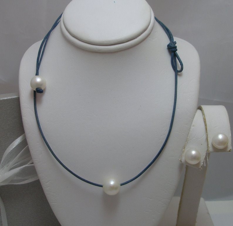 Floating Solitaire Echte Natürliche Weiße Runde Perlenkette Mit Perle Knebelverschluss Und Ohrringe Auf Leder Gesetzt Floating Solitaire Echte Natürliche Weiße Runde Perlenkette Mit Perle Knebelverschluss Und Ohrringe Auf Leder Gesetzt von Horae
