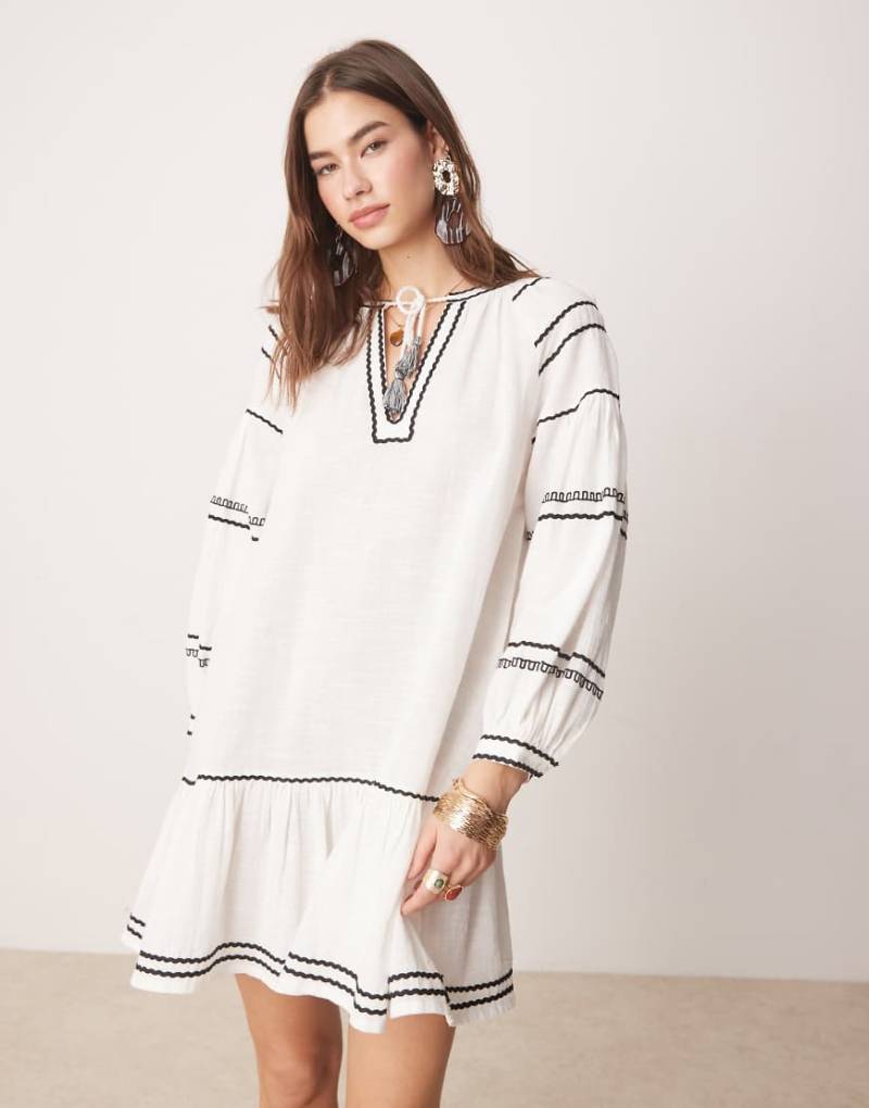 Iisla & Bird - Langärmliges Mini-Strandkleid in Weiß mit kontrastierendem Besatz von Iisla & Bird