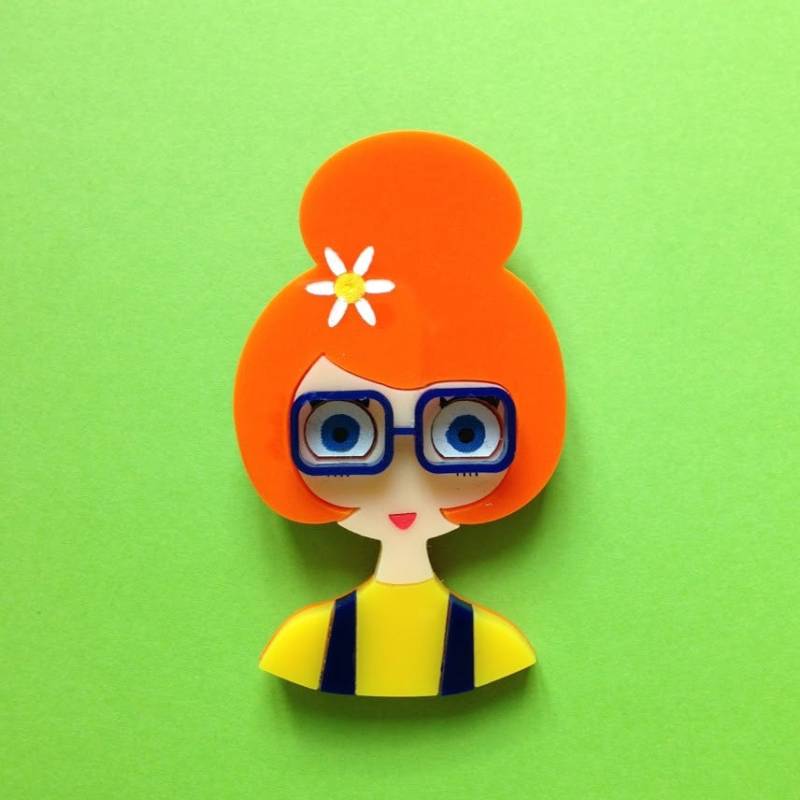 Isa Orangefarbene Acrylbrosche, Ein Mädchen Mit Einem Brötchen, Einer Blume Im Haar Und Blauen Brille Overall von IsaDuval