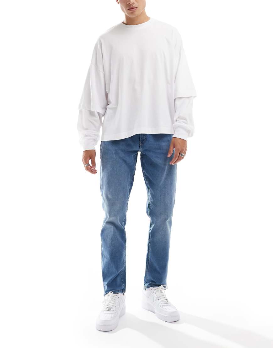 JJ Rebel - Adam - Schmal zulaufende Jeans in mittelblauer Waschung von JJ Rebel