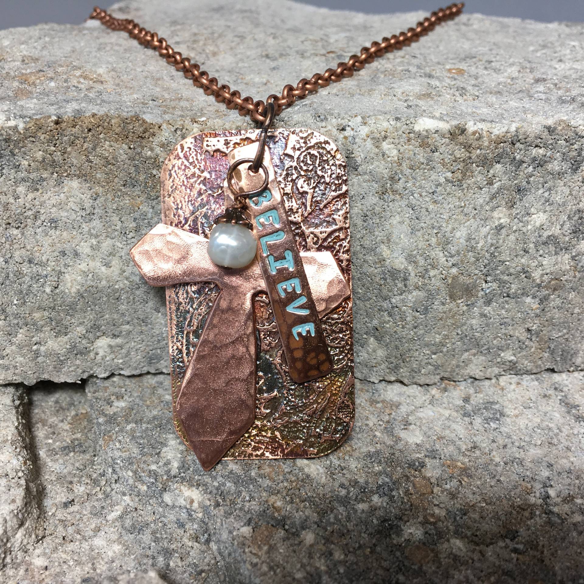 Hammered Cross Hing Vor Einzigartigem Geätztem Hintergrund Mit Einem Believe Banner Und Perle Hammered Cross Hing Vor Einzigartigem Geätztem Hintergrund Mit Einem Believe Banner Und Perle von JKMJewelryDesigns