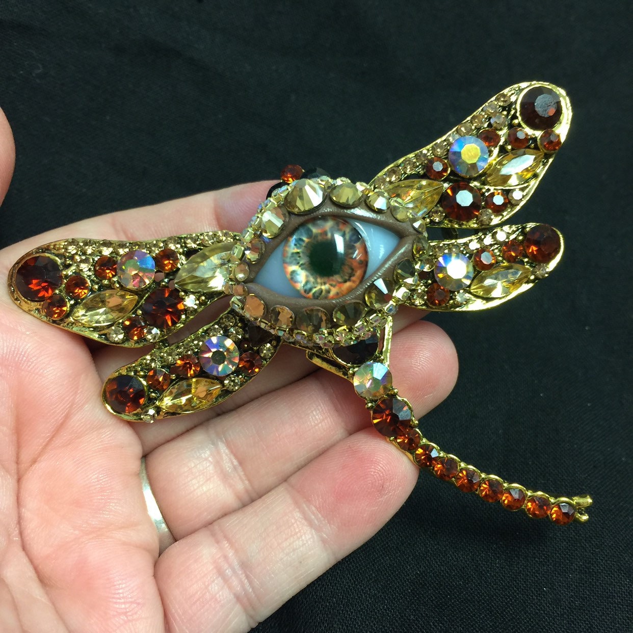 Libelle Goldene Und Bernsteinfarbene Augapfel-Kunst-Brosche Mit Handgemachter Bernsteinfarbener Glas-Iris Hand Platzierten Strasssteinen Auch Eine Libelle Goldene Und Bernsteinfarbene Augapfel-Kunst-Brosche Mit Handgemachter Bernsteinfarbener Glas-Iris Hand Platzierten Strasssteinen Auch Eine von JenBurnsArt