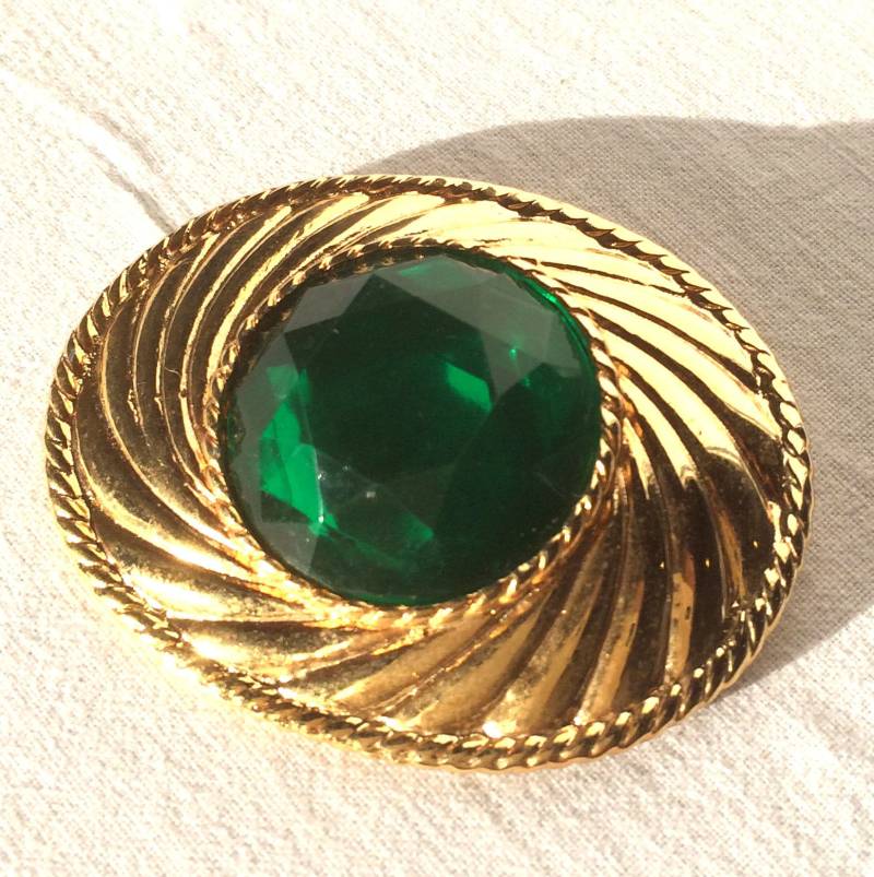Ungaro-Brosche Aus Goldenem Metall Und Smaragdgrünem Stein Mit Prägung Auf Der Rückseite Ungaro-Brosche Aus Goldenem Metall Und Smaragdgrünem Stein Mit Prägung Auf Der Rückseite von KIKINASU