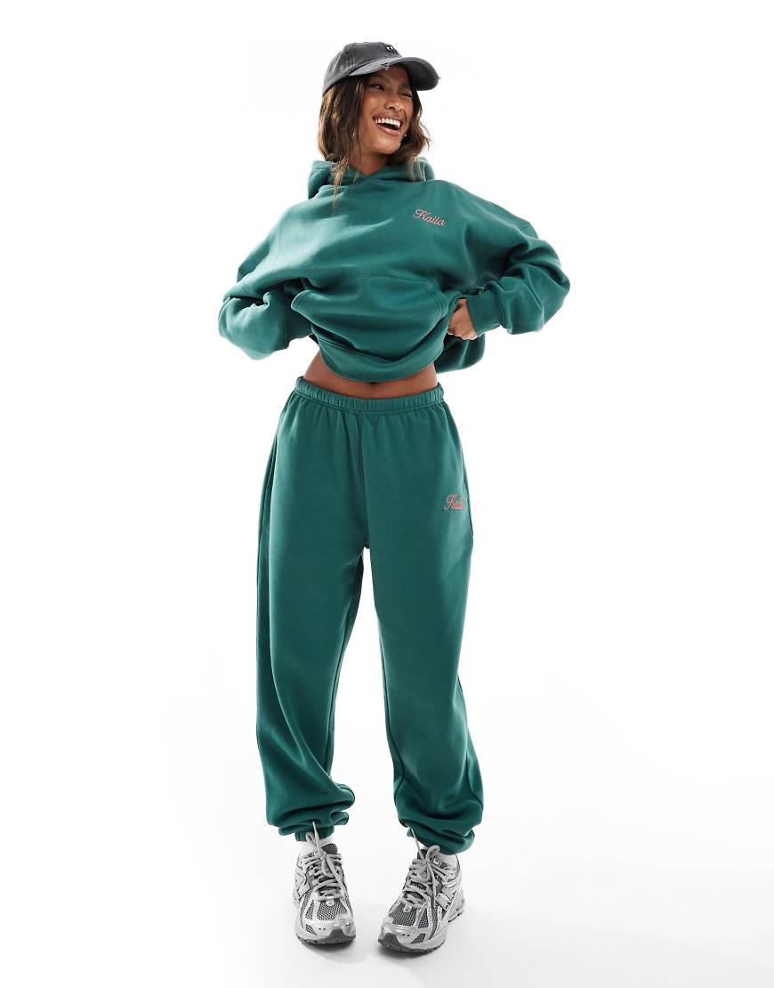 Kaiia - Jogginghose in Dunkelgrün mit Bündchen und rosa Logo, Kombiteil Kaiia - Jogginghose in Dunkelgrün mit Bündchen und rosa Logo, Kombiteil von Kaiia