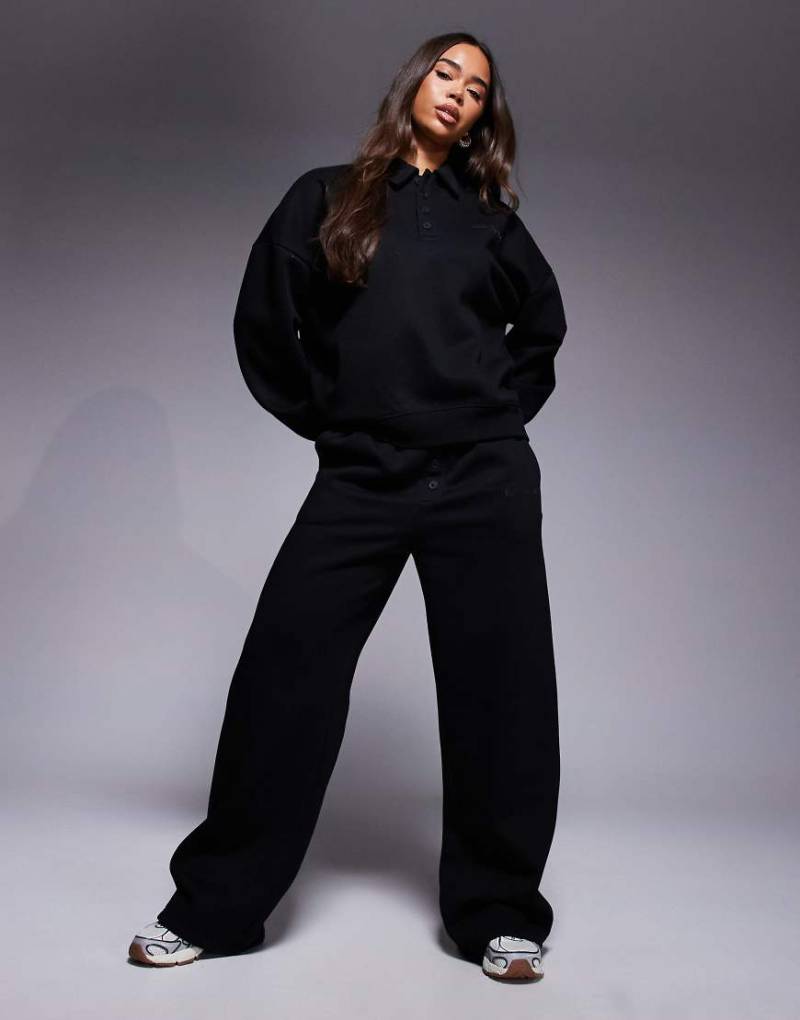 Kaiia - Jogginghose in Schwarz mit hohem Baumwollanteil, weitem Bein, Logo-Detail und Knopfleiste, Kombiteil Kaiia - Jogginghose in Schwarz mit hohem Baumwollanteil, weitem Bein, Logo-Detail und Knopfleiste, Kombiteil von Kaiia