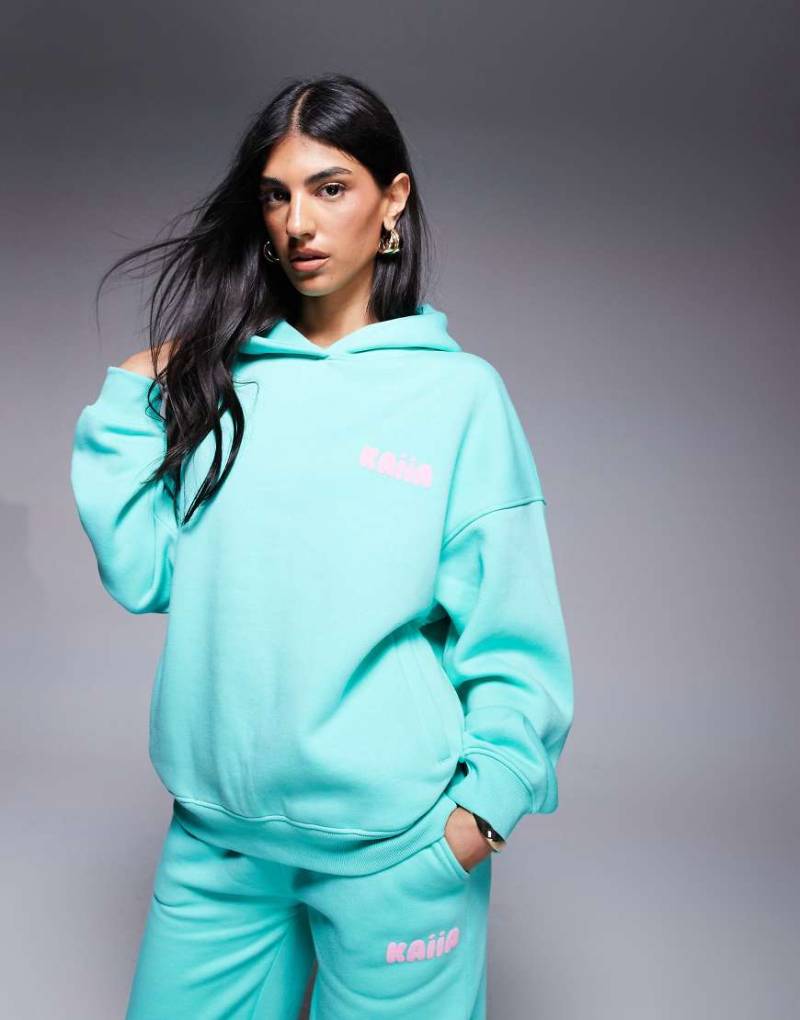 Kaiia - Oversize-Kapuzenpullover aus Baumwollmix in Aqua-Blau und Babyrosa mit Logo-Schaumprint, Kombiteil von Kaiia