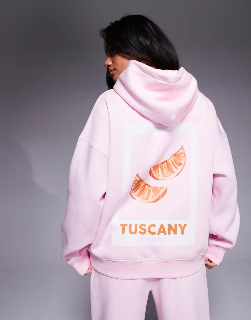 Kaiia - Oversize-Kapuzenpullover in Babyrosa mit Logostickerei, „Tuscany"-Schriftzug und Orangengrafik hinten, Kombiteil Kaiia - Oversize-Kapuzenpullover in Babyrosa mit Logostickerei, „Tuscany"-Schriftzug und Orangengrafik hinten, Kombiteil von Kaiia