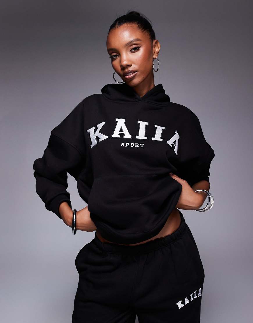 Kaiia Sport - Oversize-Kapuzenpullover in Schwarz und Cremeweiß mit Logo-Stickerei, Kombiteil Kaiia Sport - Oversize-Kapuzenpullover in Schwarz und Cremeweiß mit Logo-Stickerei, Kombiteil von Kaiia