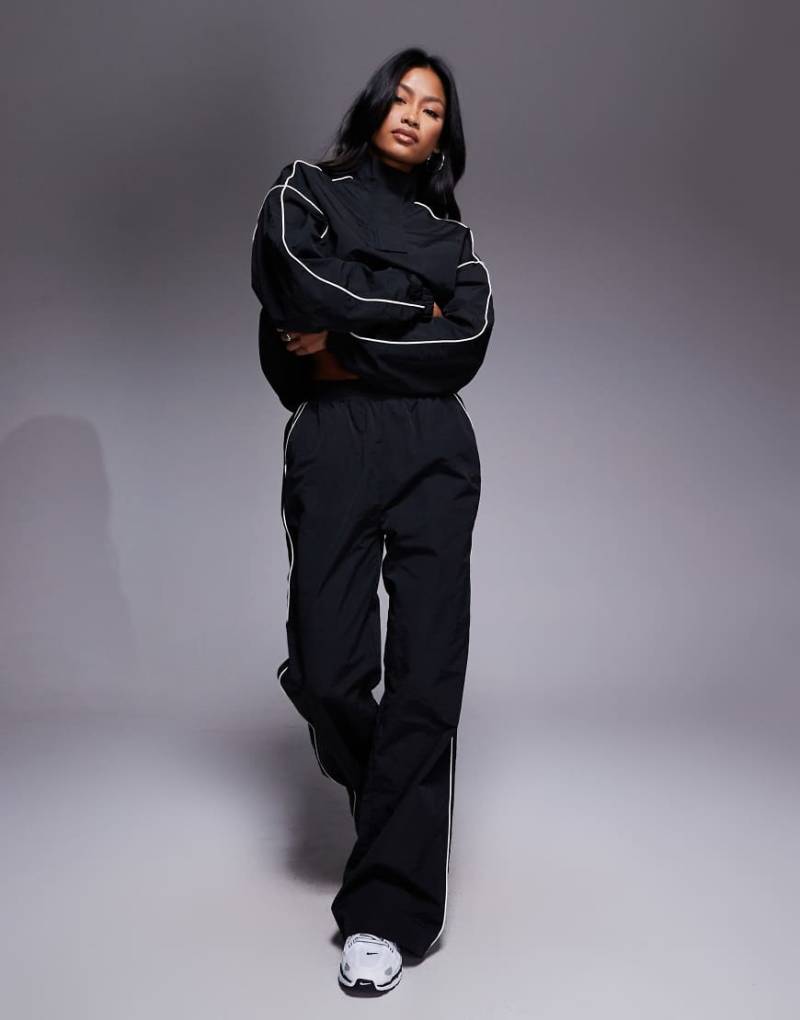 Kaiia - Sport - Windbreaker-Trainingshose in Schwarz mit Seitenstreifen-Kontrastbesatz, Kombiteil-Bunt Kaiia - Sport - Windbreaker-Trainingshose in Schwarz mit Seitenstreifen-Kontrastbesatz, Kombiteil-Bunt von Kaiia