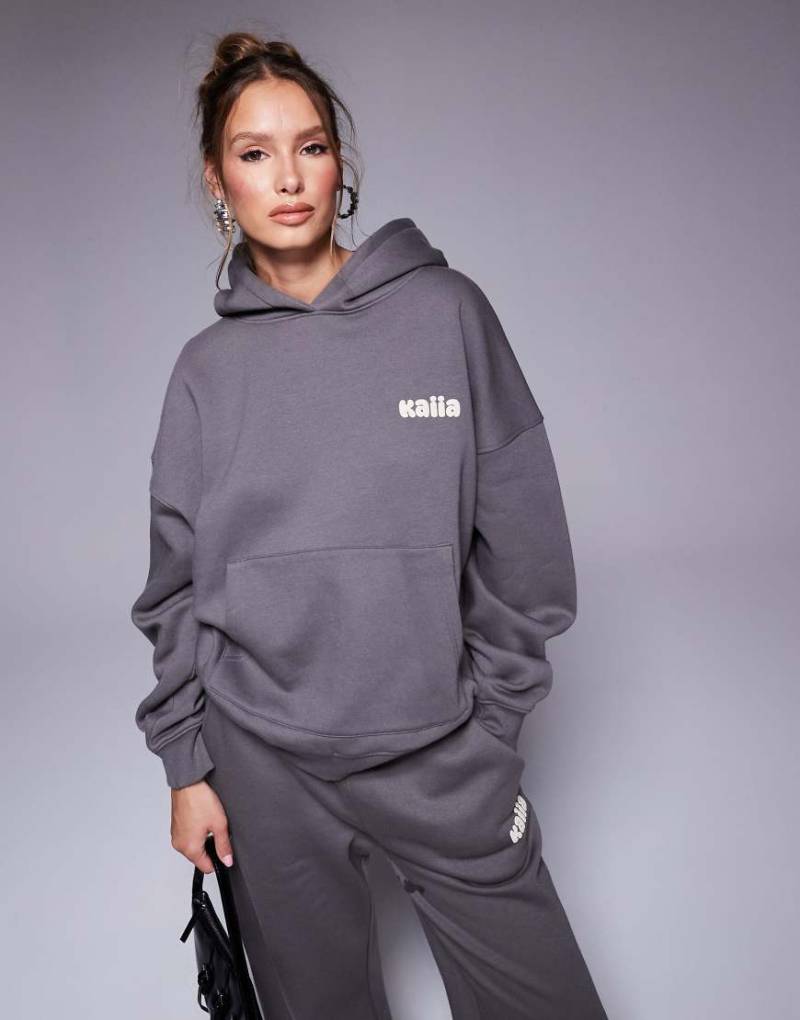 Kaiia Studio - Oversize-Kapuzenpullover in Dunkelgrau und Gelb mit Bubble-Logo auf dem Rücken, Kombiteil von Kaiia