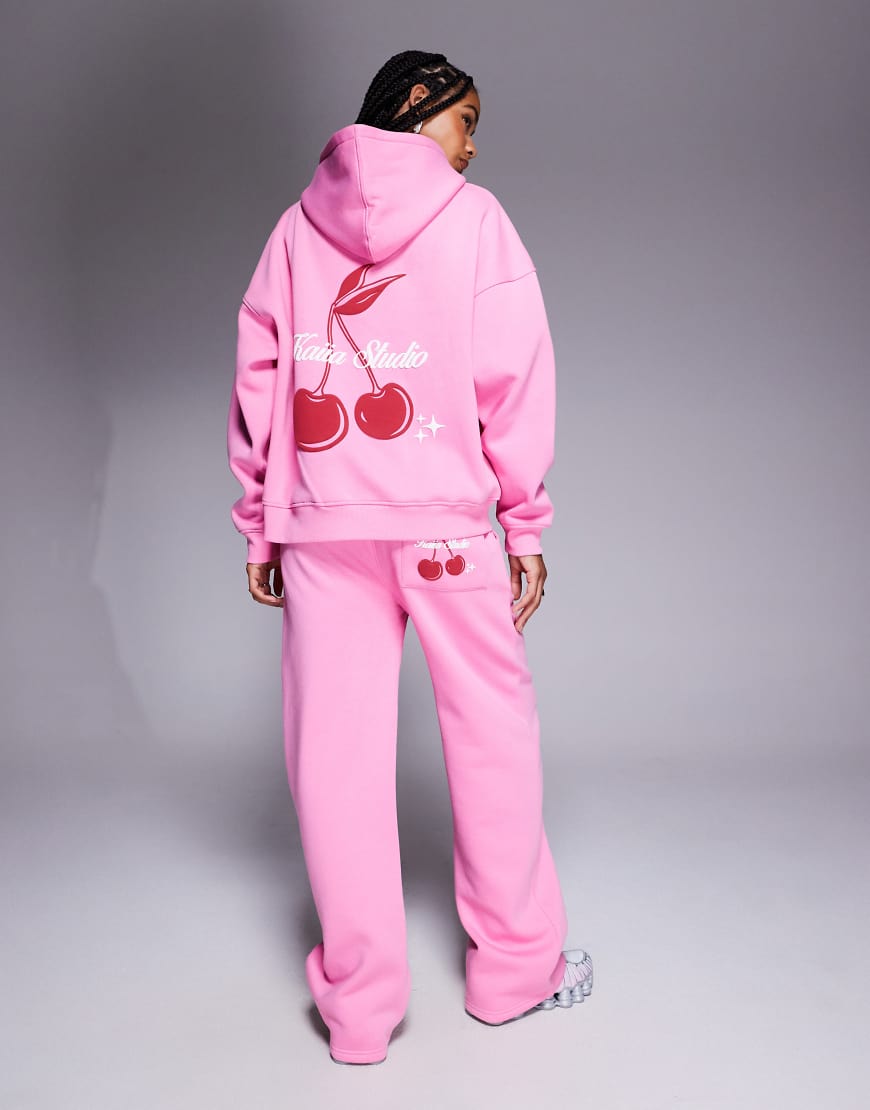 Kaiia Studio - Weit geschnittene Jogginghose mit hohem Baumwollanteil in Rosa mit Kirschprint und Taschendetail, Kombiteil Kaiia Studio - Weit geschnittene Jogginghose mit hohem Baumwollanteil in Rosa mit Kirschprint und Taschendetail, Kombiteil von Kaiia