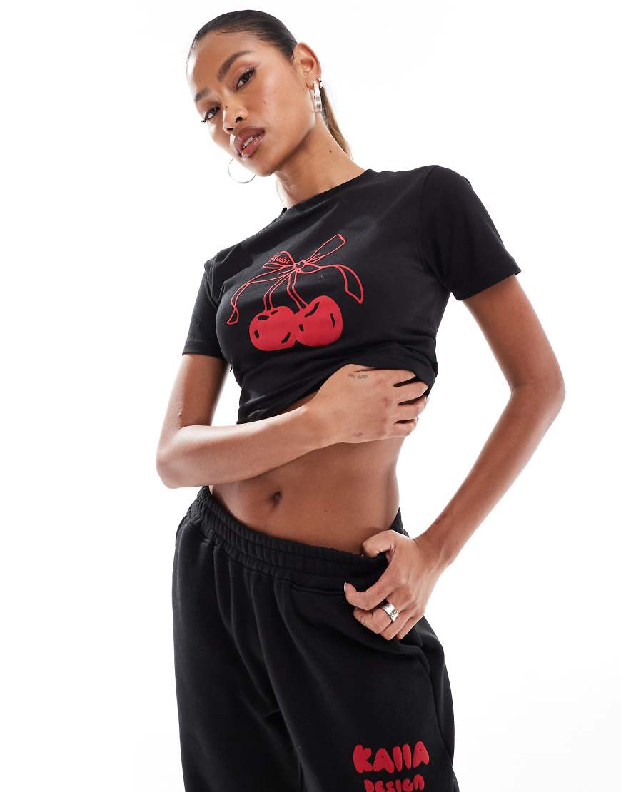 Kaiia - T-Shirt in Schwarz mit kurzem, knappem Schnitt und Schleifen- und Kirschen-Motiv, Kombiteil Kaiia - T-Shirt in Schwarz mit kurzem, knappem Schnitt und Schleifen- und Kirschen-Motiv, Kombiteil von Kaiia