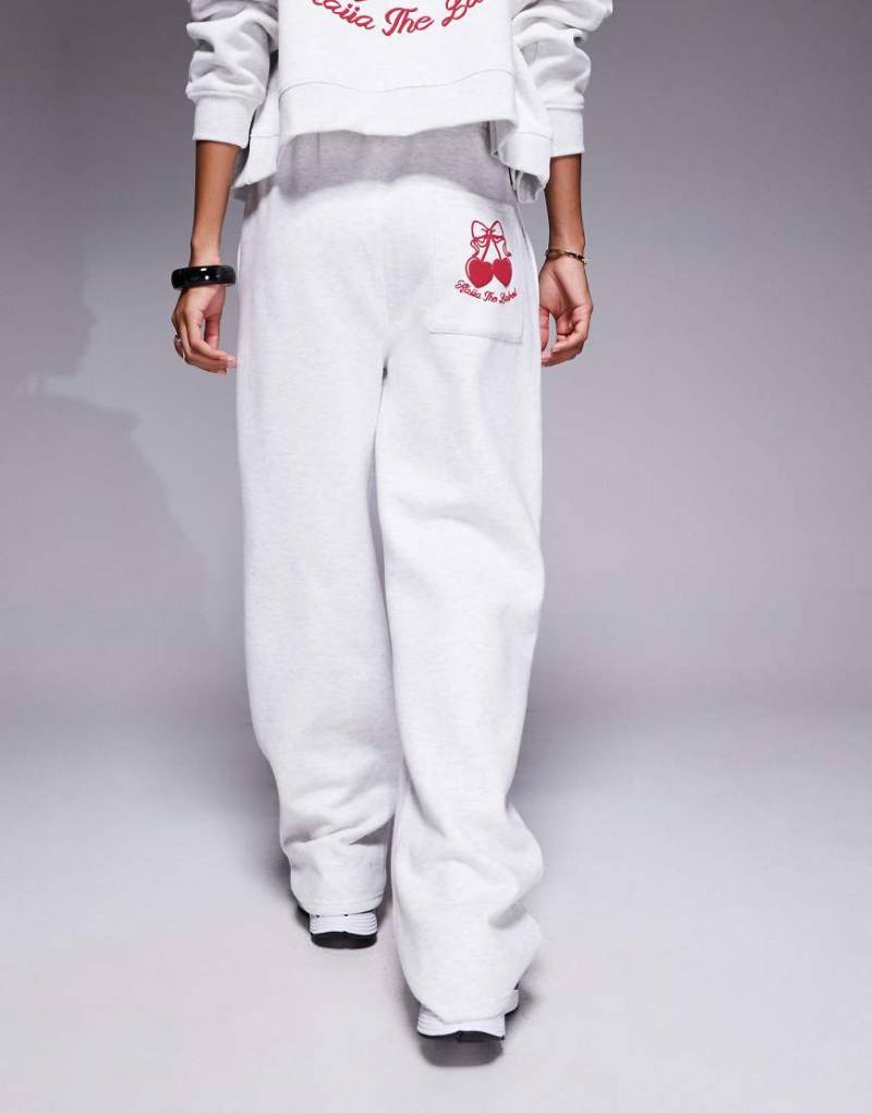 Kaiia Studio - Weit geschnittene Jogginghose mit hohem Baumwollanteil in meliertem Grau mit rotem Kirschprint und Taschendetail, Kombiteil von Kaiia