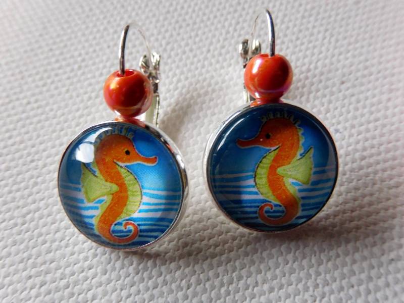 Versilberte Leverback Ohrringe 16 Mm Mit Farbenfrohen Seepferdchen Motiv in Orange Blau Und Kleiner Perle Versilberte Leverback Ohrringe 16 Mm Mit Farbenfrohen Seepferdchen Motiv in Orange Blau Und Kleiner Perle von KielerArt