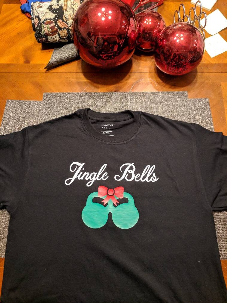 Jingle Bells Kettlebell-Fitness-studio Grafik-T-Shirt von KinneysKornerStudio