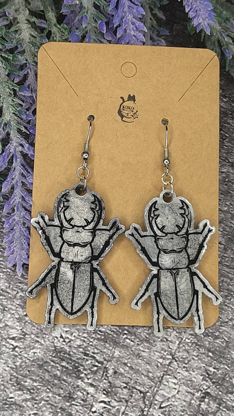 Weiß-Schwarze Melierte Hirschkäfer Ohrringe Mit Schwarzen Outlines von KokoCrafting