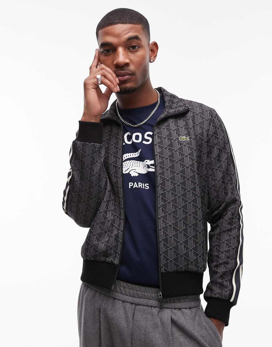 Lacoste - Trainingsjacke in Schwarz mit Monogram-Muster, Kombiteil Lacoste - Trainingsjacke in Schwarz mit Monogram-Muster, Kombiteil von Lacoste