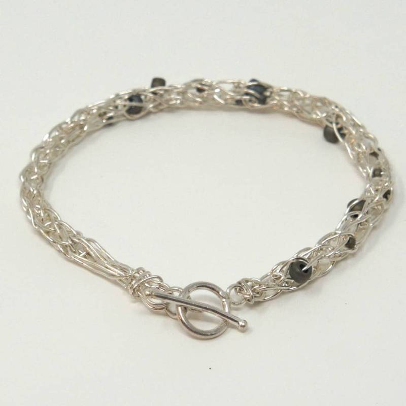 Feines Silberfarbenes Gehäkeltes Armband Mit Grauen Perlen Und T-Verschluss Feines Silberfarbenes Gehäkeltes Armband Mit Grauen Perlen Und T-Verschluss von LaurieRhoads