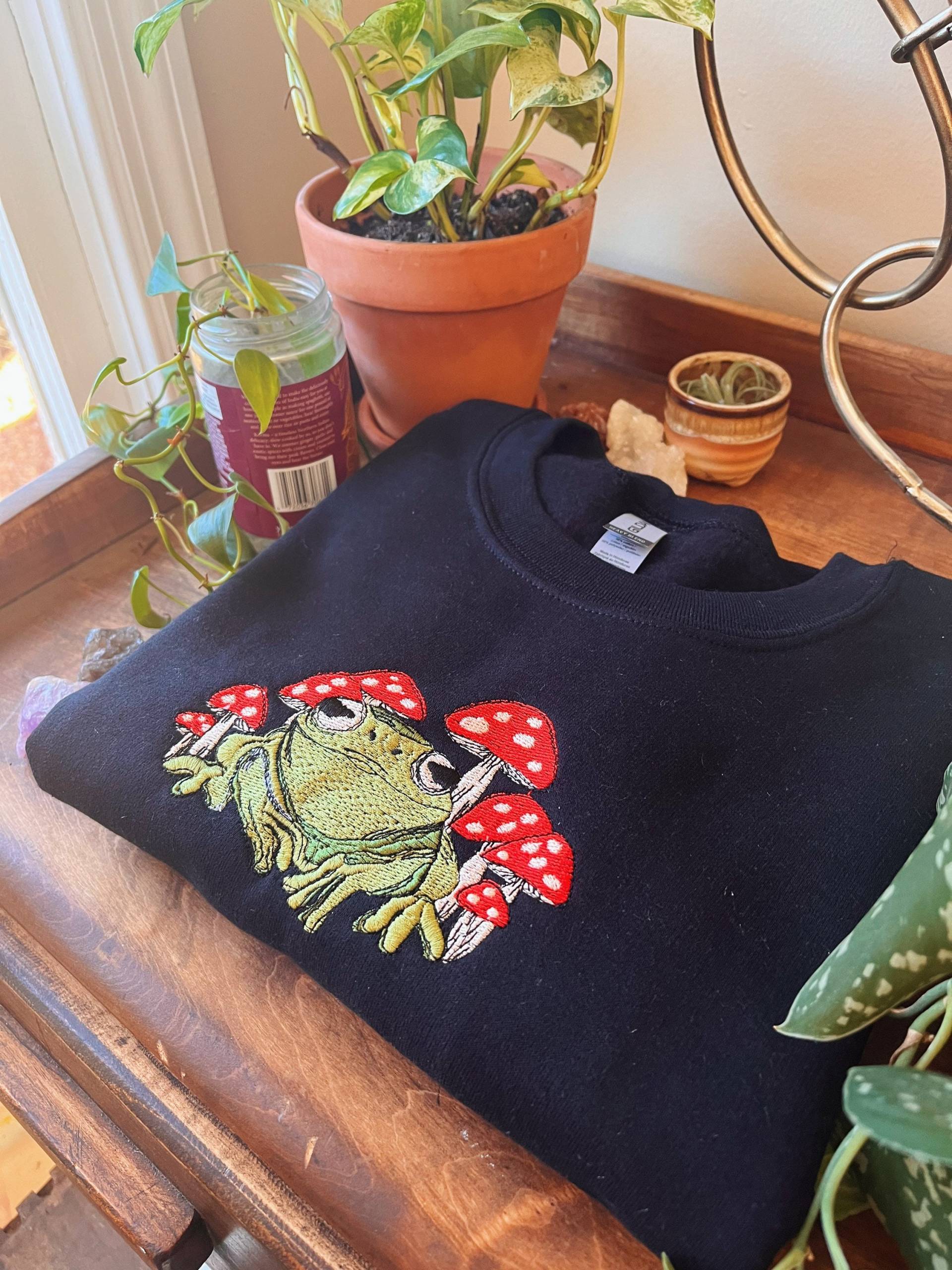 Schwarzer Frosch Pilz Crewneck - Unisex Bestickter Boho Fleece Pullover Custom Besticktes Sweatshirt Hippie Bekleidung Schwarzer Frosch Pilz Crewneck - Unisex Bestickter Boho Fleece Pullover Custom Besticktes Sweatshirt Hippie Bekleidung von LeBeauDenimCompany