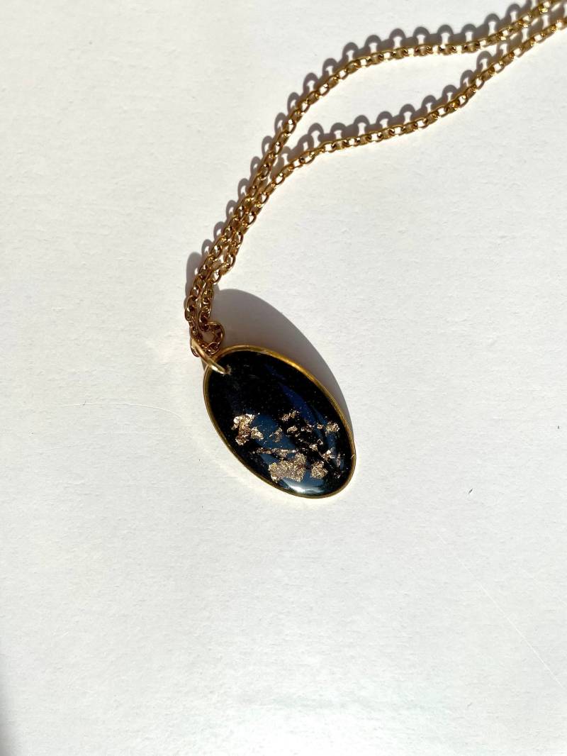 Ovaler Kettenanhänger Mit Goldflocken Und Schwarzem Epoxidharz An Vergoldeter Kette Aus Edelstahl Ovaler Kettenanhänger Mit Goldflocken Und Schwarzem Epoxidharz An Vergoldeter Kette Aus Edelstahl von LeniellaJewellery
