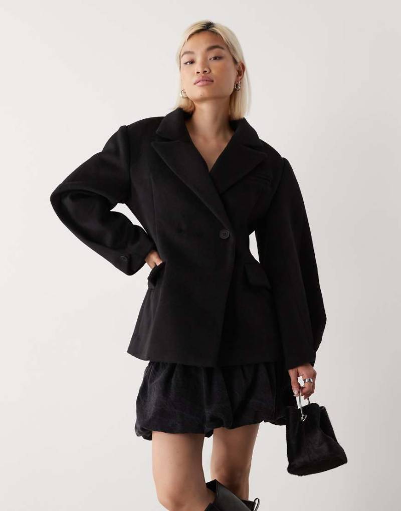 Lioness - Herzförmiger zweireihiger und taillierter Mantel mit Wollhaptik in Schwarz und abgerundeten, weiten Ärmeln von Lioness