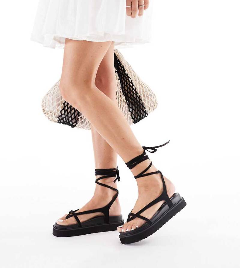 London Rebel Wide Fit - Zehenstegsandalen aus schwarzem Wildlederimitat mit Riemchen-Details von London Rebel Wide Fit